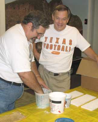 Mike Kremheller supervises as Charlie Richmond mixes Hydrocal to make castings at APN